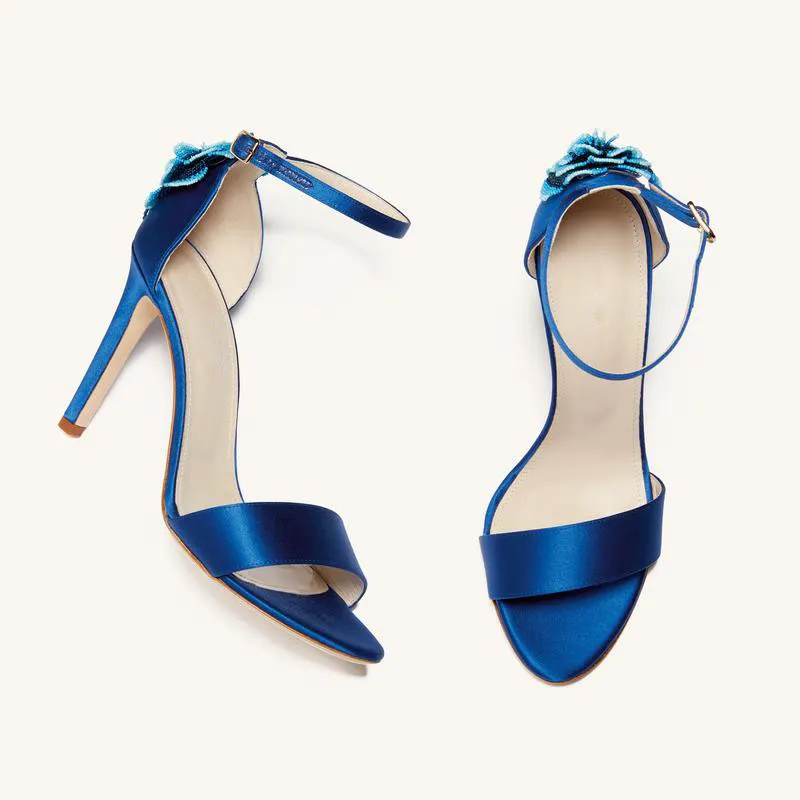 Top View of Blue Satin Sandals with Floral Design Top view of blue satin sandals with floral embellishment and ankle strap.