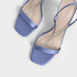 Top view of purple satin sandals with rhinestone crisscross straps by Lajwanti Designers.